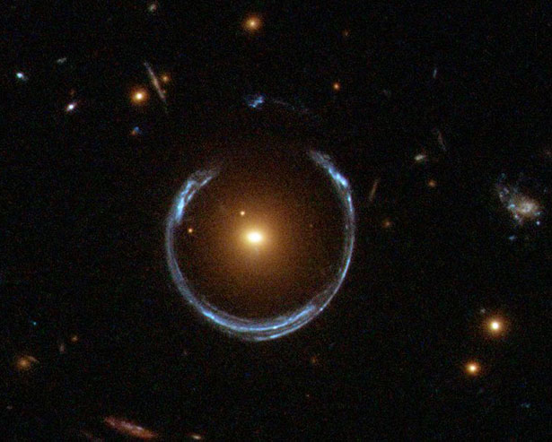 Diese Aufnahme des Weltraumteleskops Hubble zeigt den Gravitationslinsen-Effekt: Die Galaxie im Zentrum verzerrt das Licht dahinterliegender Lichtquellen zu einem Ring.