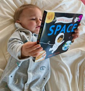 Baby liest ein Buch über das Weltall