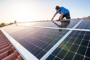Techniker bei der Dachmontage von Solarpanels