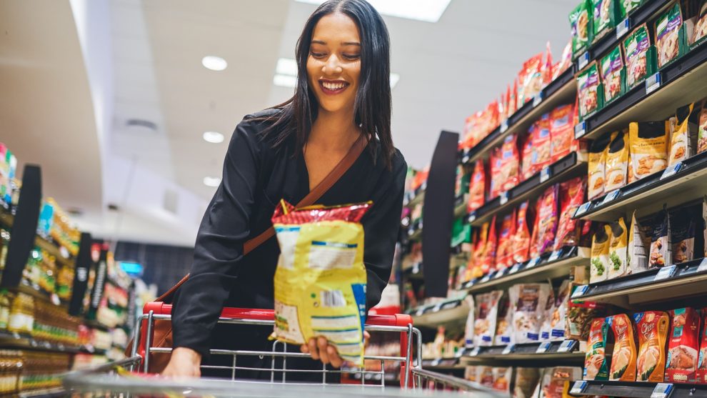 Junge Frau beim Snackskauf im Supermarkt