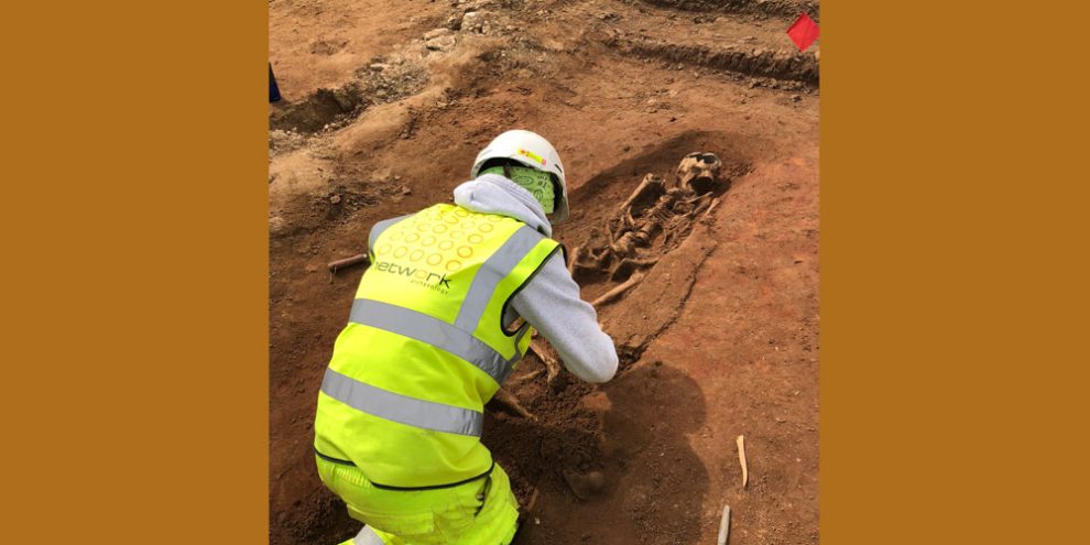 Archäologe bei der Ausgrabung eines Skeletts